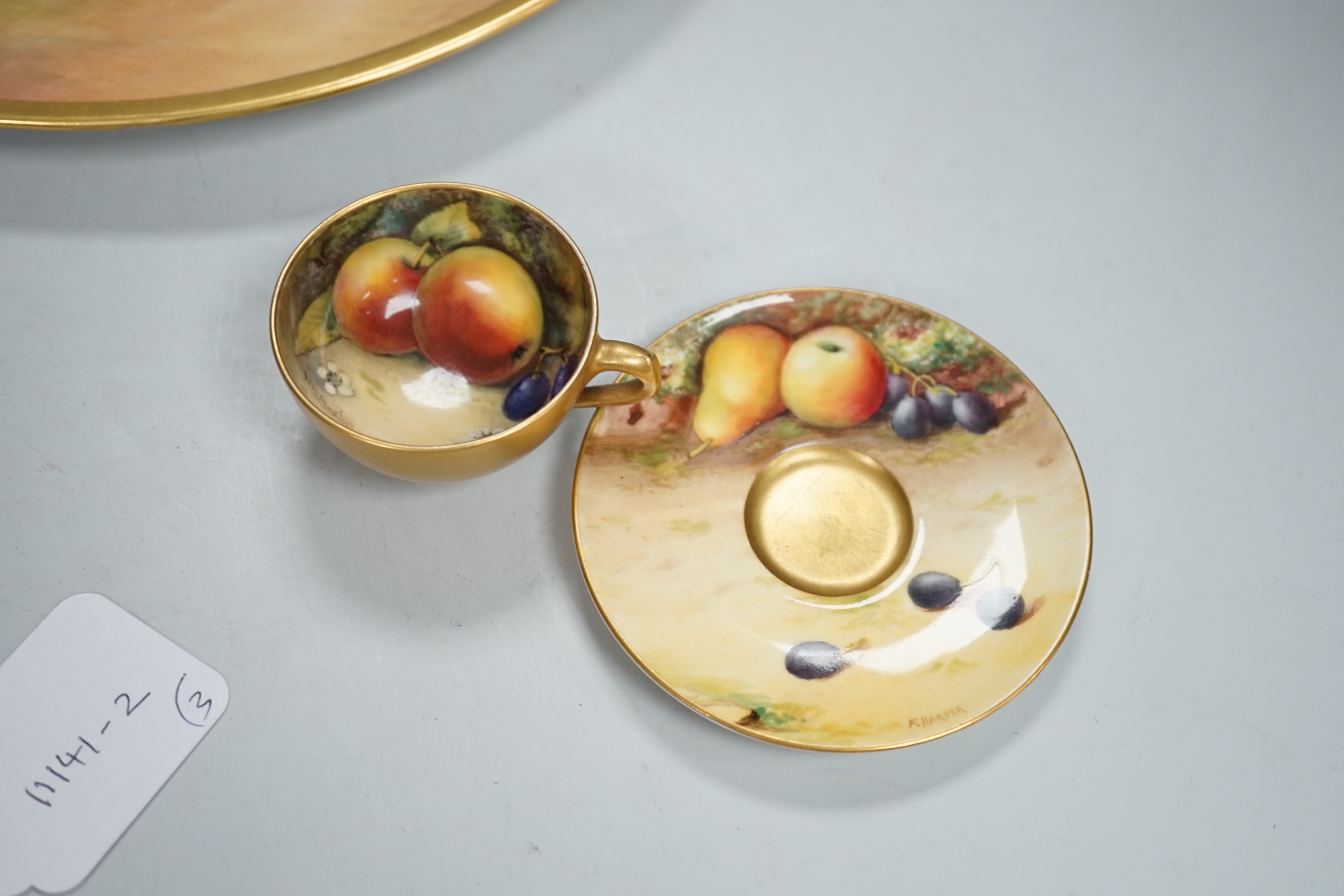 A large fruit painted dish by R. Budd and a Royal Worcester fruit painted miniature tea cup and saucer painted by F Harper and W H Austin, largest 32cm in diameter